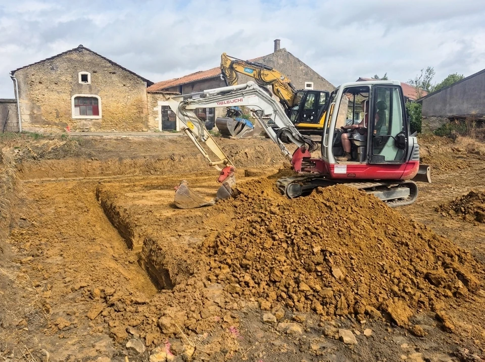 Chantier de construction urbain en extérieur avec travaux de terrassement et revêtement routier en cours